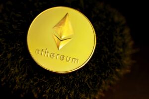 Como imagen destacada de este texto sobre lo que debes saber de Ethereum, tenemos una fotografía de un moneda digital de esta en color dorado donde se ve el nombre y el logo de la criptomoneda y plataforma digital.