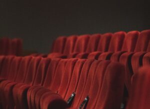 En este texto sobre 3 películas de emprendimientos hemos seleccionado como imagen destacada la fotografía de unas butacas rojas, numeradas e iluminadas, dentro de un cine vacío.