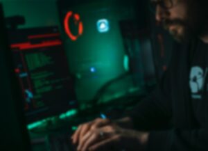 Para este texto sobre un informe de Microsoft indica que ciberespías rusos lanzaron ciberataques de ciberespionaje contra aliados de Ucrania tenemos una imagen ilustrativa donde vemos a un hombre trabajando en código en su computadora.
