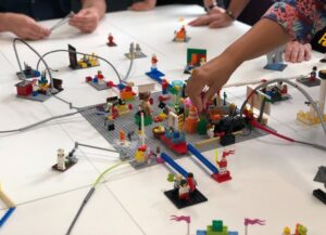 Como imagen destacada para este texto sobre lo que sabemos de la nueva y única fábrica de Lego en Estados Unidos (EU) tenemos una fotografía de personajes y construcciones de la firma siendo manipuladas por una persona, sobre una mesa.