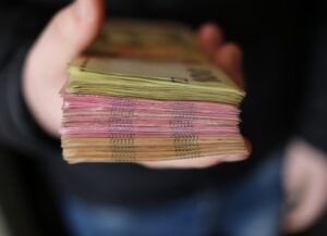 Para esta nota sobre el límite a pagos en efectivo en México, como prevención al lavado de dinero, tenemos como imagen destacada la fotografía de un fajo de billetes sostenido por una mano.