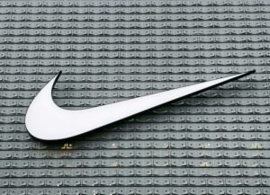 Como imagen destacada de este texto sobre la despedida de Nike del mercado ruso, ante la invasión de Rusia a Ucrania, tenemos una fotografía del logo de la compañía en blanco, sobre la fachada de un edificio en gris.
