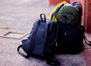 Para este texto sobre cómo aumentan los días de vacaciones en México para la personas trabajadoras, de acuerdo con la Ley Federal del Trabajo, tenemos de imagen destacada una fotografía de una mochila, una maleta y una bolsa de dormir en el suelo.