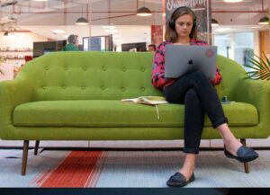 Como imagen destacada para este texto sobre 5 ganadoras del Latino Founders Fund, tenemos una fotografía en la que vemos a una mujer sentada en un sillón verde, quien trabaja en la computadora portátil que tiene en las piernas.