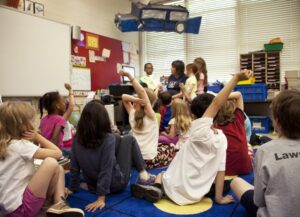 El flipped classroom, conocido también como aula invertida o clase invertida, adapta la enseñanza necesidades específicas; para imagen destacada del texto al respecto, tenemos una fotografía de un grupo de alumnos sentados en el suelo d Eunices salón de clases, en lo que podría ser una exposición.