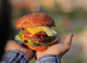 Para este texto sobre la venta de la marca Burger boy tenemos una fotografía de una hamburguesa sostenida por un par de manos