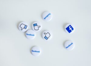 Para este texto titulado: Beneficios de usar Facebook para tu negocio, tenemos una imagen destacada en la que vemos círculos blancos con el logo de la red social, su nombre y el signo de like.