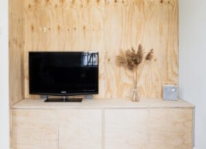 Como imagen destacada para este texto sobre Google TV y los canales que promete tenemos una imagen destacada de una televisión apagada sobre un mueble de madera.