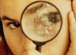 Si es te interesa invertir y diversificar tus negocios, por medio de las franquicias, aquí te compartimos 5 cosas que debes saber de ellas con un texto que tiene como imagen destacada la fotografía d una mujer con una lupa frente a su ojo.