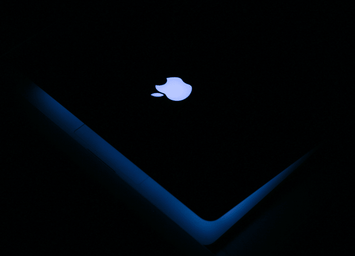 Como imagen destacada para este texto titulado: Acciones récord de Apple, tenemos una fotografía del logo de la empresa en un computadora.