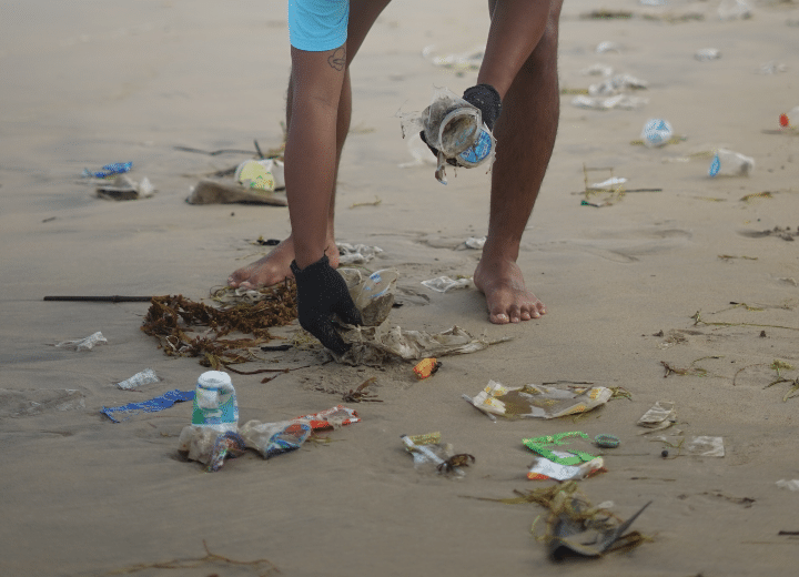 Como imagen destacada para este texto titulado: ¿Qué es el emprendimiento de triple impacto?, tenemos una fotografía ilustrativa de una persona limpiando una playa.