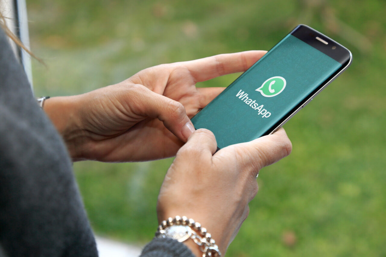 Como imagen destacada para este texto en el que hablamos del moto otoño en WhatsApp, tenemos una fotografía ilustrativa de una mujer que está abriendo la aplicación con su celular en la mano.