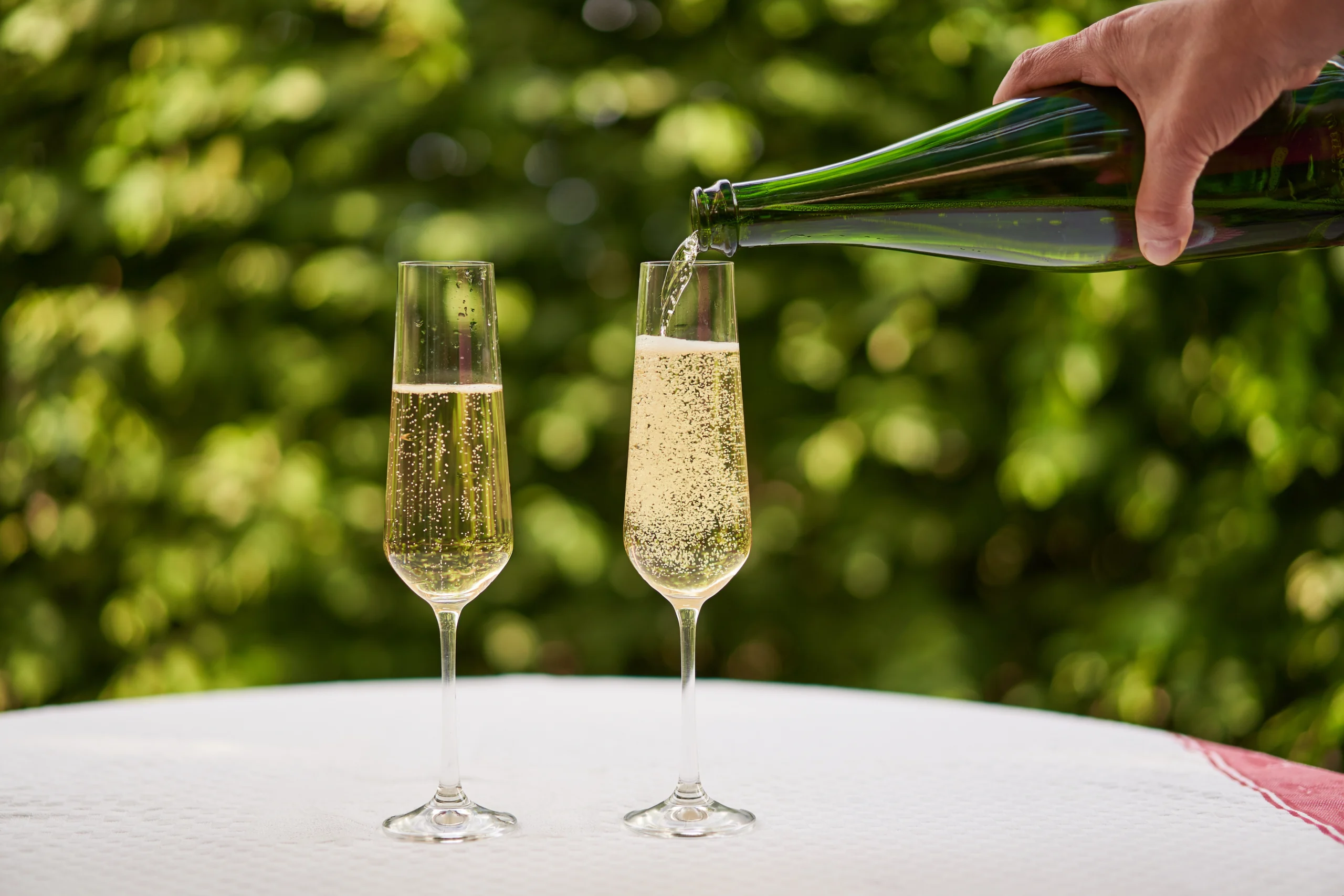 Como imagen destacada para este texto en el que hablamos del retiro de un vino Prosecco de cadena de autoservicio Costco, tenemos una fotografía ilustrativa de una mano sirviendo dos copas de vino espumoso. 