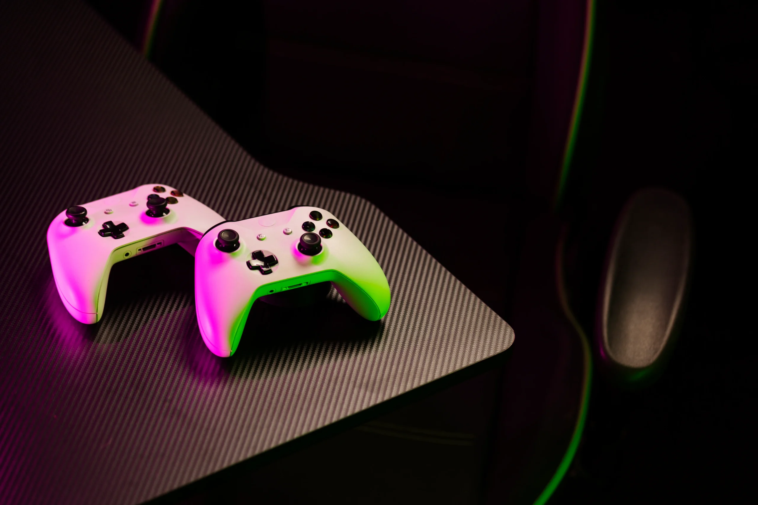 Como imagen destacada para este texto en el que hablamos de la integración de Xbox y LG a las pantallas de los coches a través del game pass, tenemos una fotografía ilustrativa con dos controles de Xbox sobre una silla gaming. 
