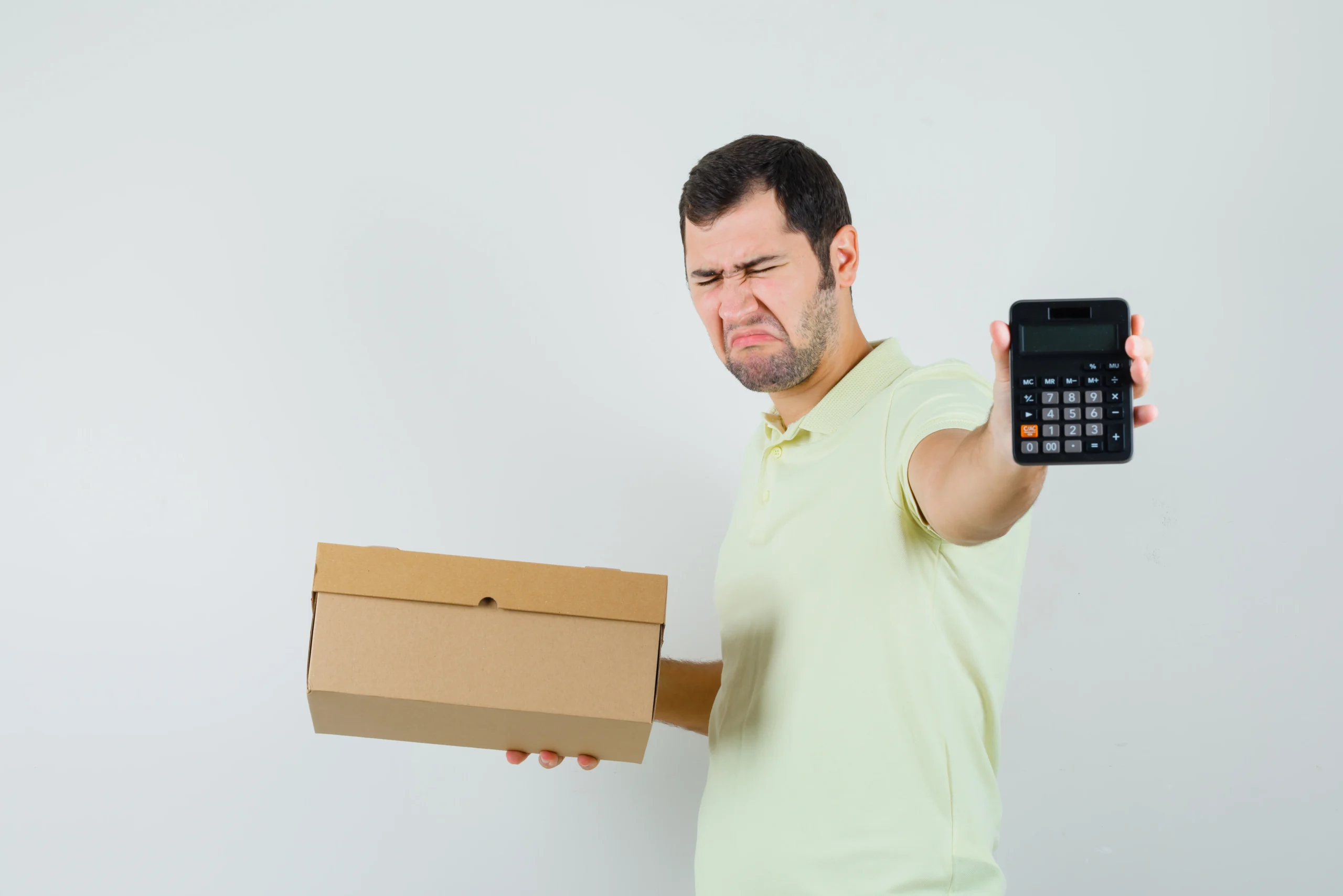 Como imagen destacada para este texto en el que hablamos del Paquete Económico 2026, tenemos una fotografía ilustrativa de  un joven con una  caja de cartón y una calculadora.