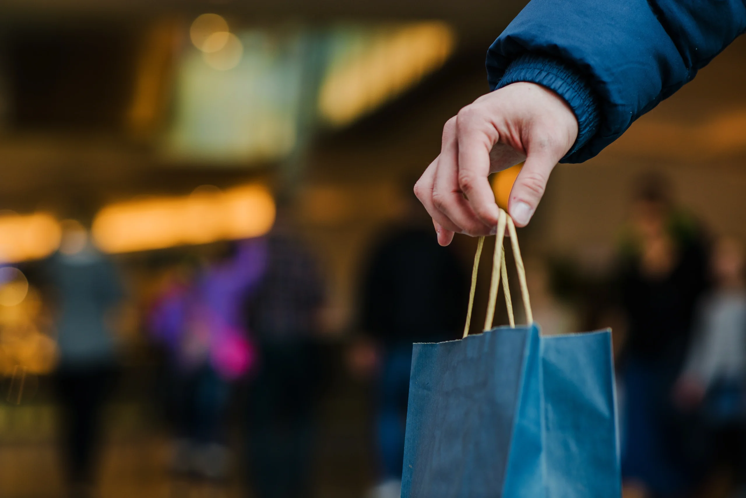 Como imagen destacada para este texto en el que hablamos de la temporada baja de ventas en una franquicia, tenemos una fotografía ilustrativa de una mano sosteniendo una bolsa de compras.