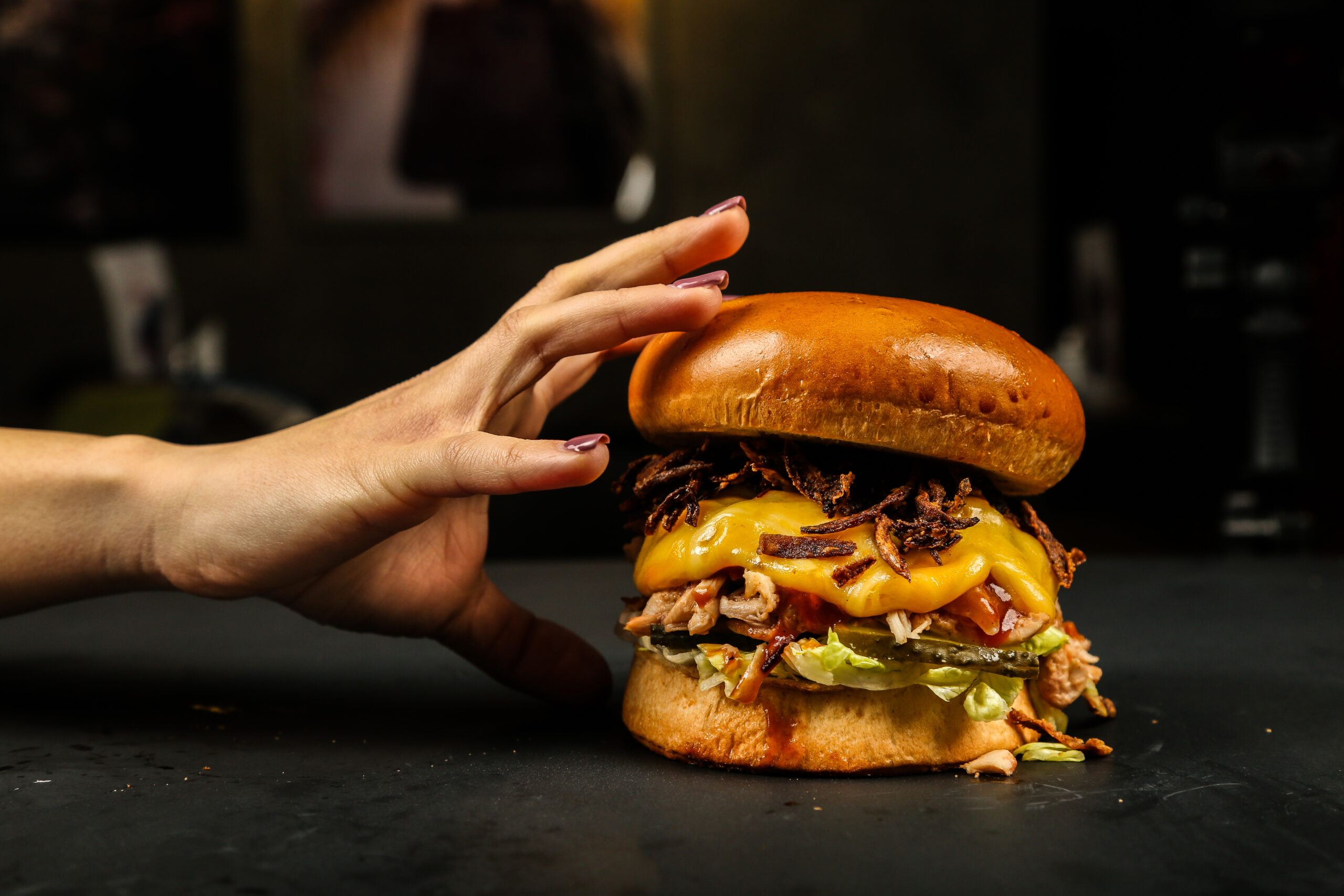 Como imagen destacada para este texto en el hablamos de una edición limitada de la hamburguesa mexicana, tenemos una fotografía ilustrativa de una mano sosteniendo una hamburguesa. 