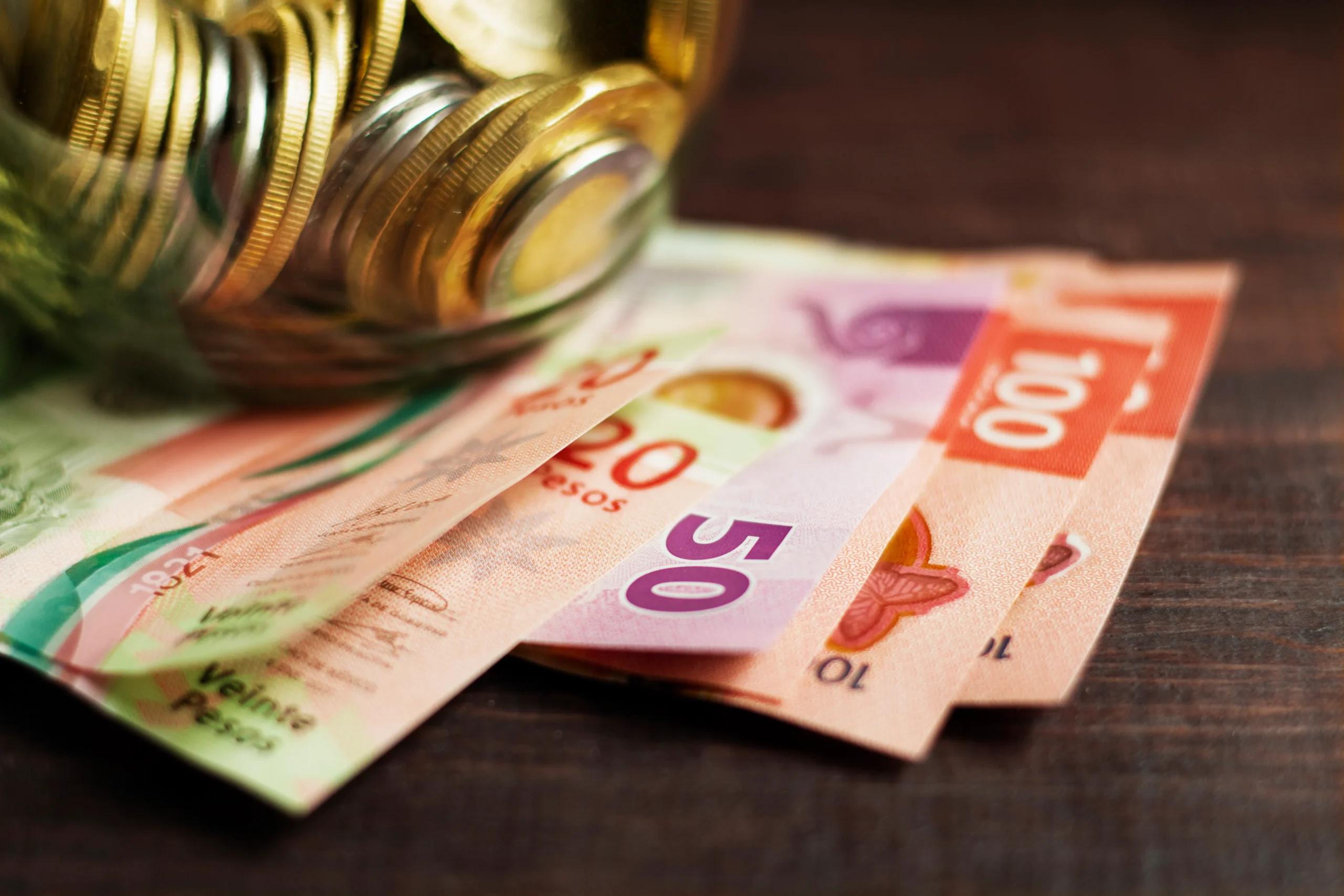 Como imagen destacada para este texto en el que hablamos del aguinaldo de 40 días, tenemos una imágen ilustrativa de monedas y billetes cayendo de una alcancía.