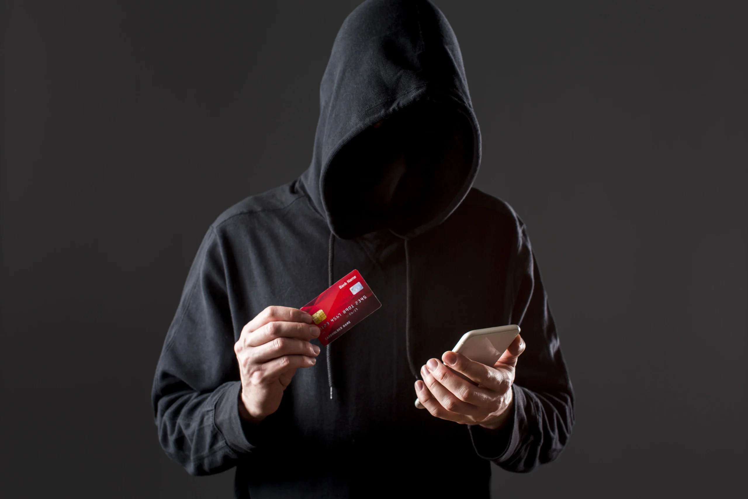 Como imagen destacada para este texto en el que hablamos de los fraudes por SPEI, tenemos una fotografía ilustrativa de una persona con una tarjeta y un teléfono en la mano.