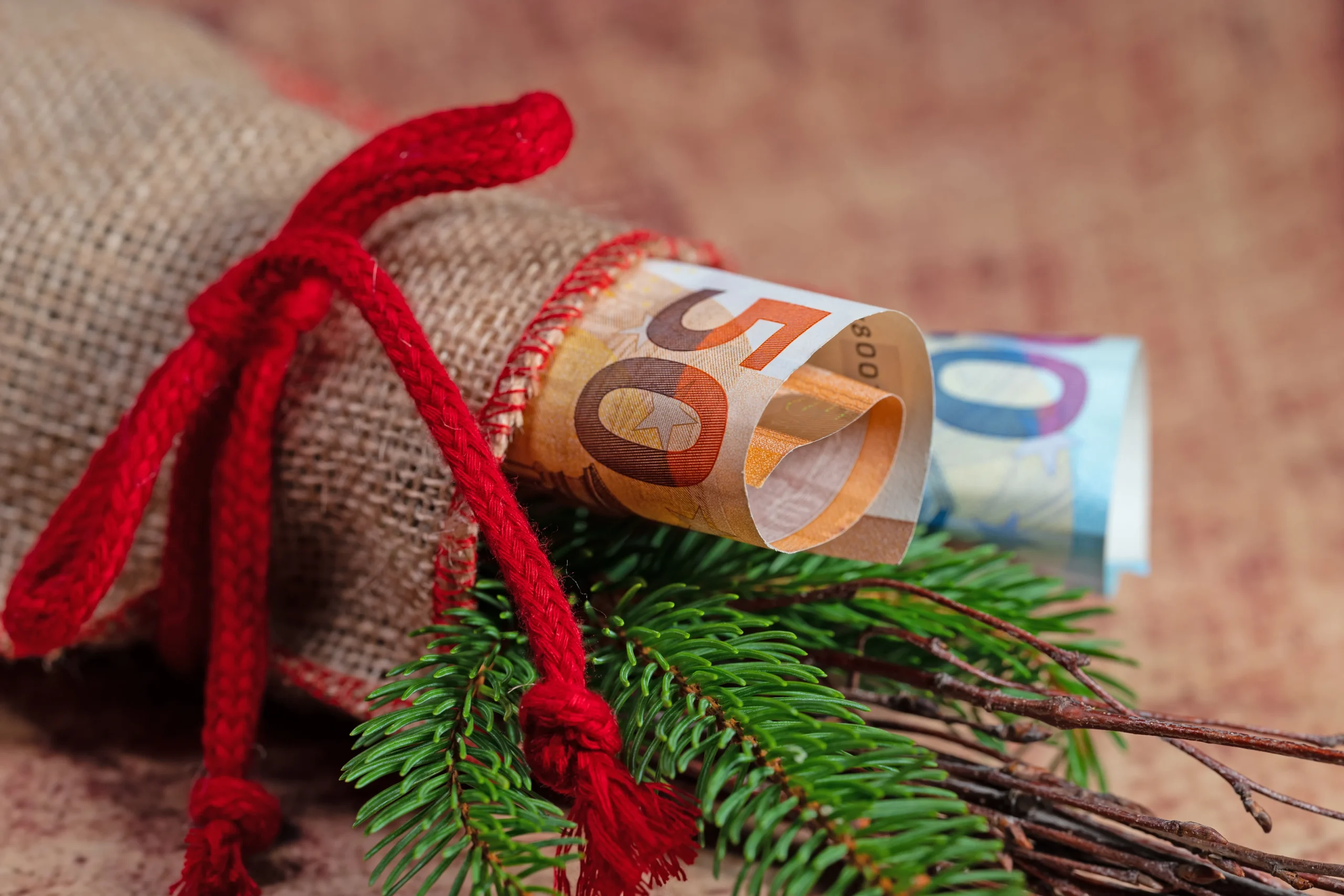 Como imagen destacada para este texto en el que hablamos de cómo administrar el aguinaldo, tenemos una imágen ilustrativa de billetes de diferente denominación envueltos para regalo.