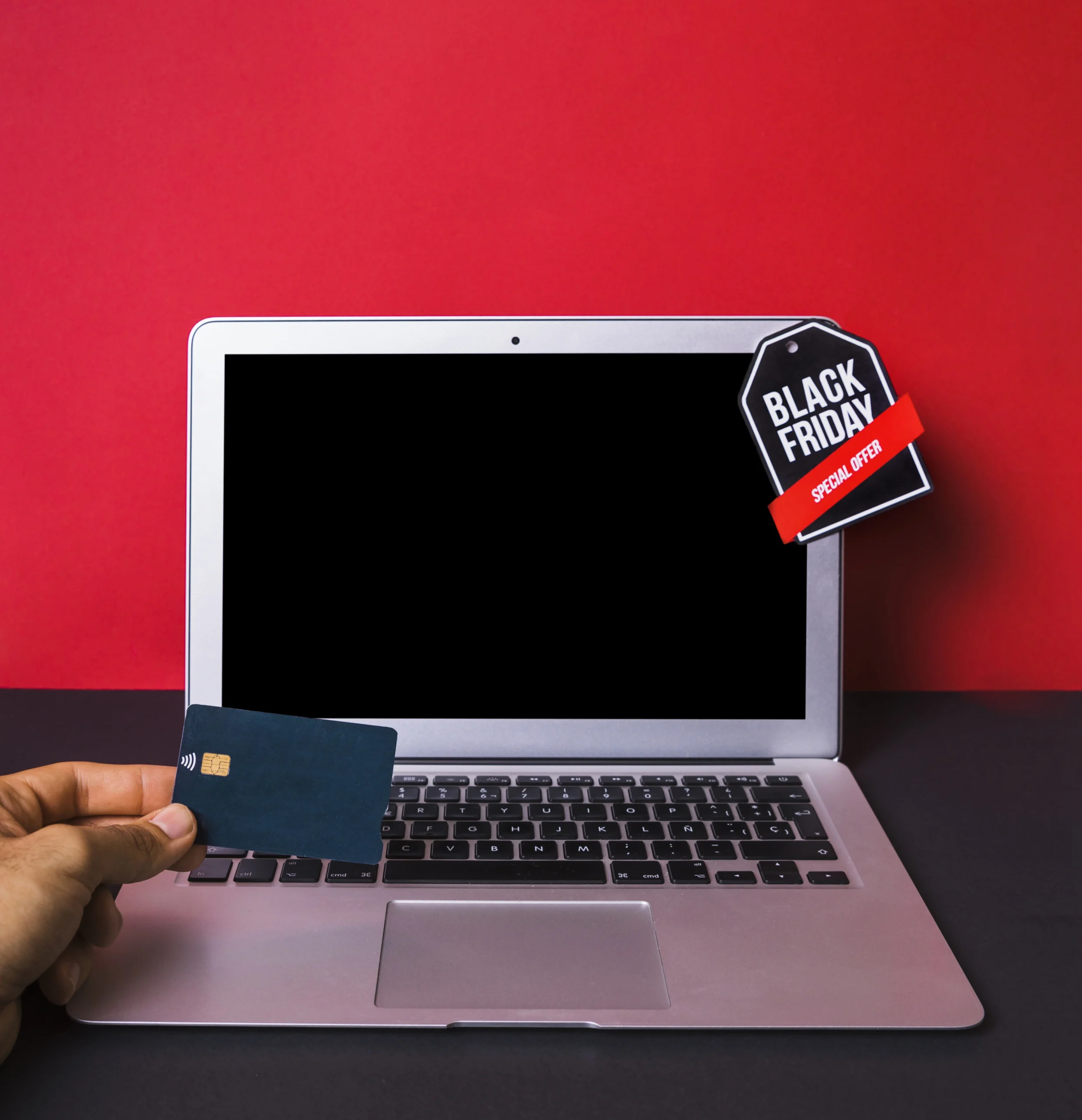 Como imagen destacada para este texto en el que hablamos de las Black Friday 2025, tenemos una imágen ilustrativa de una mano sosteniendo una tarjeta de crédito frente a una computadora.